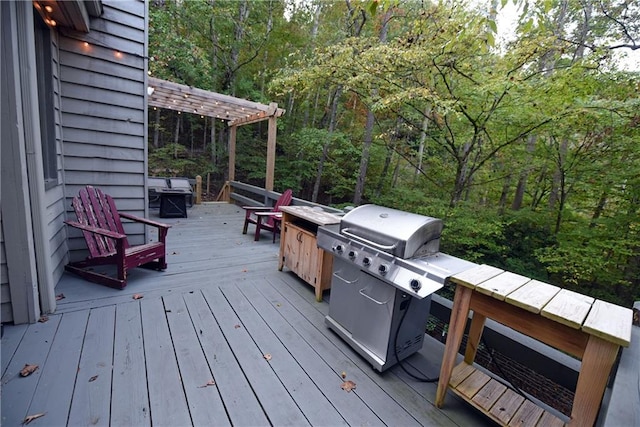 wooden terrace with grilling area and a pergola