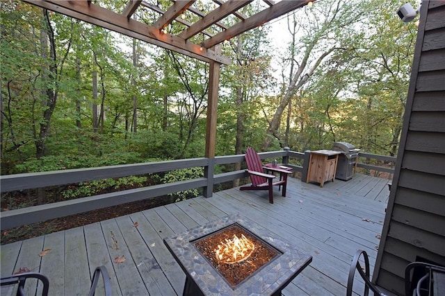 wooden deck with area for grilling and a fire pit