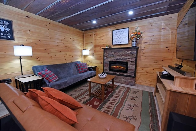 living room with a stone fireplace, hardwood / wood-style flooring, and wooden walls