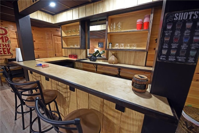 bar featuring wooden walls and light wood-type flooring