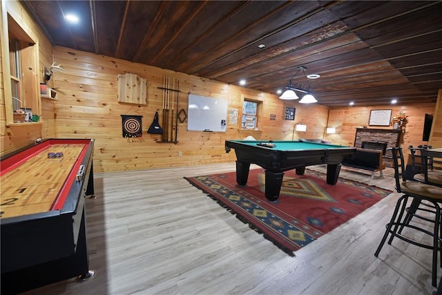 game room featuring light hardwood / wood-style flooring, wooden walls, wooden ceiling, and a fireplace