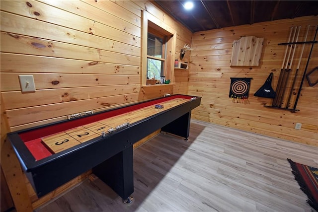 game room with wood-type flooring and wood walls