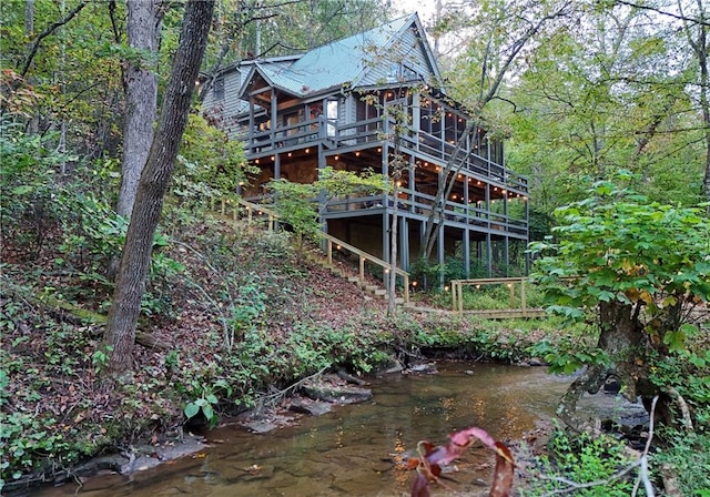 view of home's exterior featuring a deck with water view