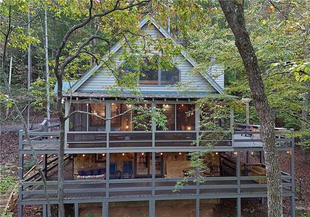 back of house featuring a wooden deck and a sunroom