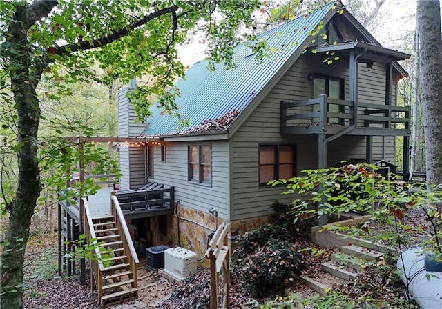 view of side of home featuring a wooden deck and central AC