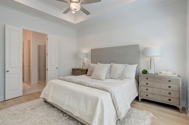 bedroom with baseboards, a raised ceiling, ceiling fan, and wood finished floors