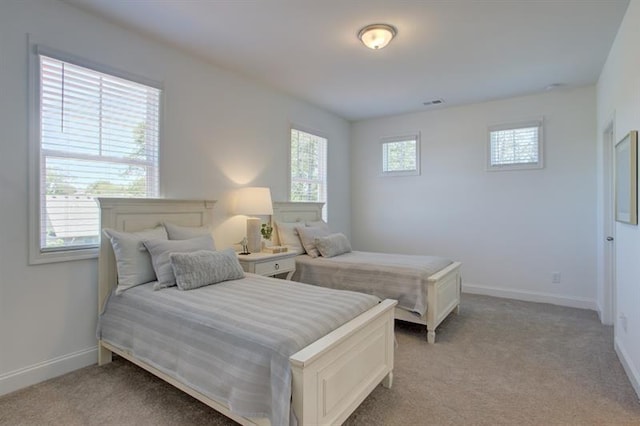 bedroom featuring baseboards, light carpet, and visible vents