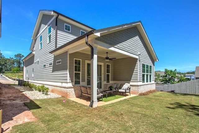 rear view of property featuring a lawn, an outdoor living space, a patio, fence, and ceiling fan