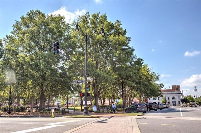 view of road with street lights, curbs, sidewalks, and traffic lights