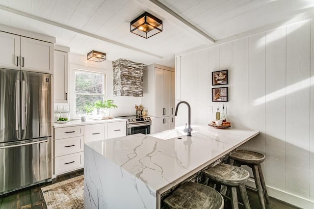 242 Buckskull Hollow Dr, Jasper, GA 30143 - kitchen featuring appliances with stainless steel finishes, a sink, light stone counters, wood finished floors, and a kitchen bar