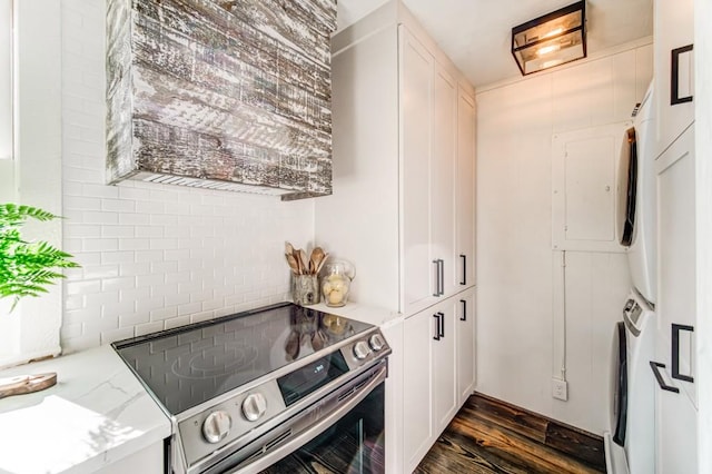 242 Buckskull Hollow Dr, Jasper, GA 30143 - kitchen with stainless steel electric range, stacked washer / drying machine, dark wood-type flooring, white cabinets, and light stone countertops
