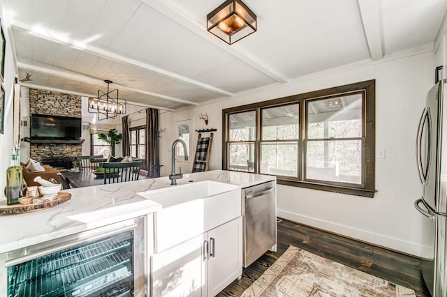 242 Buckskull Hollow Dr, Jasper, GA 30143 - kitchen featuring stainless steel appliances, beam ceiling, light stone countertops, dark wood finished floors, and white cabinetry