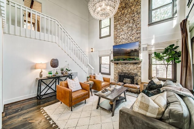 242 Buckskull Hollow Dr, Jasper, GA 30143 - living room with a high ceiling, stairway, a stone fireplace, wood finished floors, and a chandelier