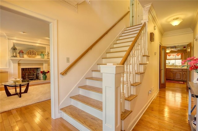 stairs featuring wood-type flooring and crown molding