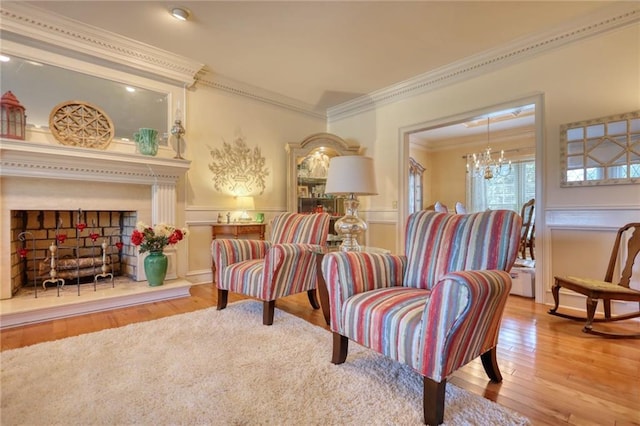 sitting room featuring light hardwood / wood-style floors, ornamental molding, and an inviting chandelier