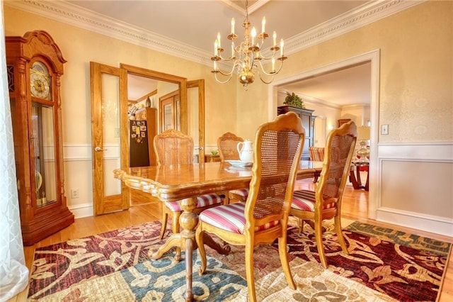 dining space with french doors, light hardwood / wood-style floors, an inviting chandelier, and ornamental molding