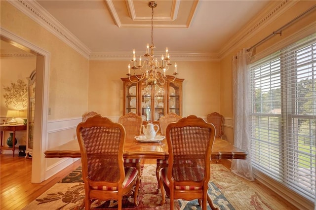 dining area with light hardwood / wood-style flooring, a chandelier, and ornamental molding