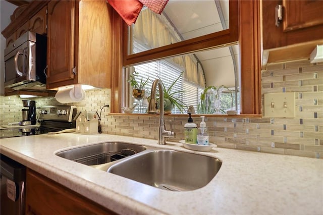 kitchen featuring decorative backsplash, stainless steel appliances, and sink