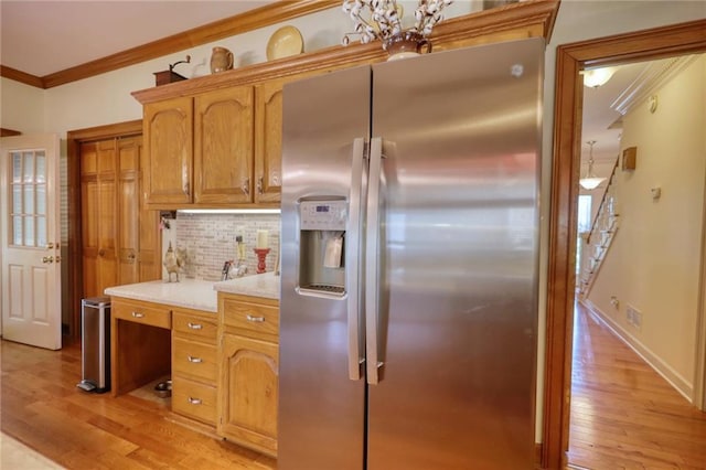 kitchen featuring stainless steel refrigerator with ice dispenser, tasteful backsplash, light hardwood / wood-style flooring, and ornamental molding