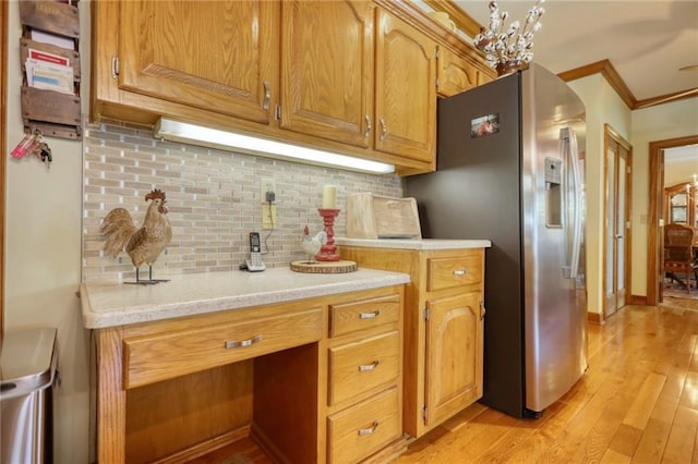 kitchen featuring light wood-type flooring, backsplash, crown molding, a chandelier, and stainless steel fridge with ice dispenser