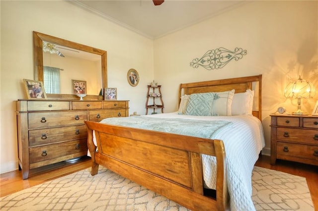 bedroom with hardwood / wood-style flooring, ceiling fan, and crown molding