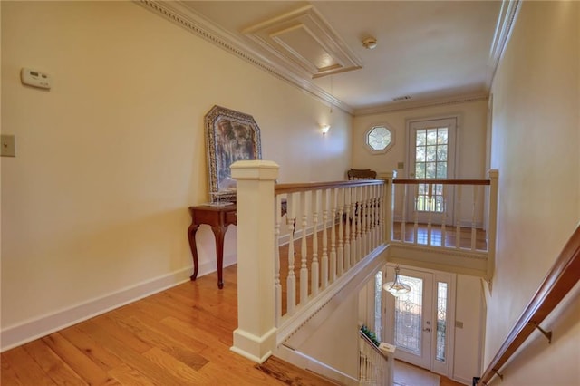 staircase with ornamental molding and hardwood / wood-style flooring