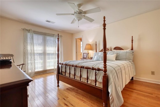 bedroom featuring ceiling fan, crown molding, and light hardwood / wood-style floors