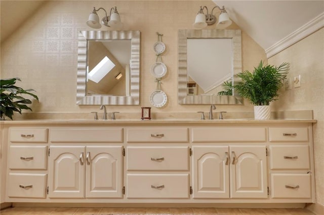 bathroom featuring vaulted ceiling with skylight, vanity, and ornamental molding