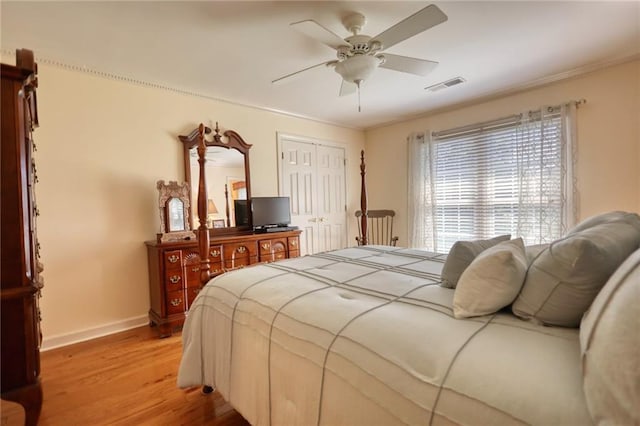 bedroom featuring crown molding, ceiling fan, a closet, and light hardwood / wood-style floors