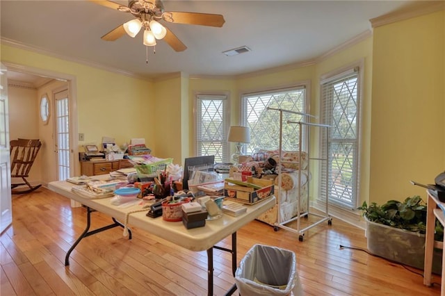 office area with light wood-type flooring, ceiling fan, and ornamental molding