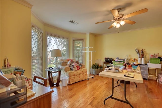 home office featuring ceiling fan, light wood-type flooring, and ornamental molding