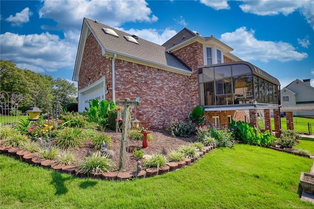 rear view of property featuring a yard and a garage