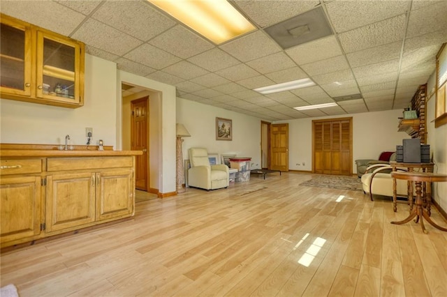 interior space with a paneled ceiling and light wood-type flooring