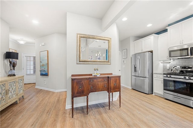 kitchen with white cabinetry, light wood-style floors, tasteful backsplash, and appliances with stainless steel finishes