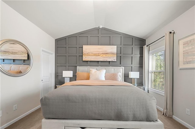 bedroom featuring baseboards, vaulted ceiling, carpet flooring, and a decorative wall