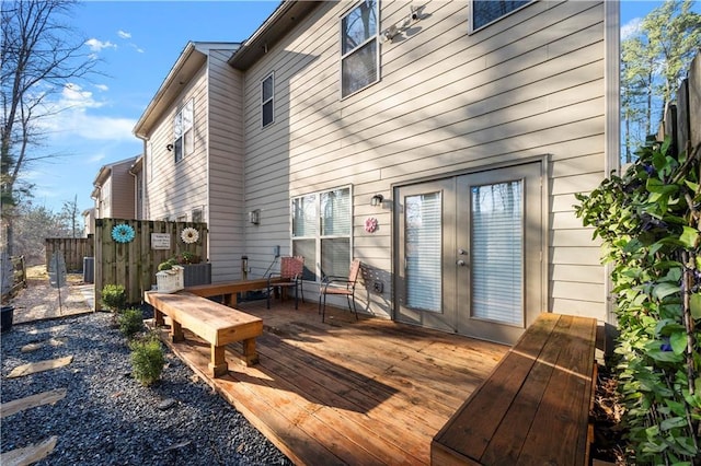 rear view of house with a deck and fence