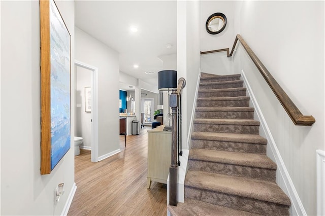 stairs featuring recessed lighting, baseboards, and wood finished floors