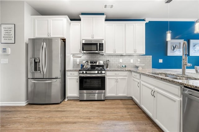 kitchen featuring visible vents, light wood-style flooring, stainless steel appliances, white cabinetry, and a sink