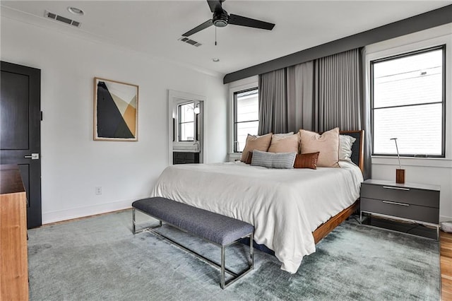 bedroom featuring ceiling fan, ornamental molding, hardwood / wood-style floors, and multiple windows