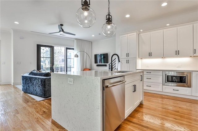 kitchen with sink, white cabinetry, an island with sink, stainless steel appliances, and light hardwood / wood-style floors