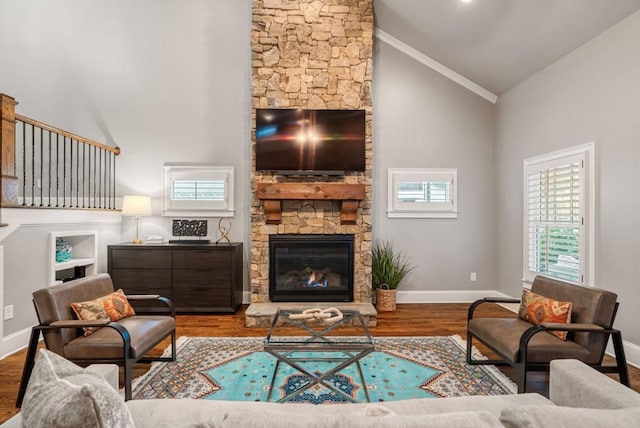 living room featuring hardwood / wood-style floors, a stone fireplace, and high vaulted ceiling