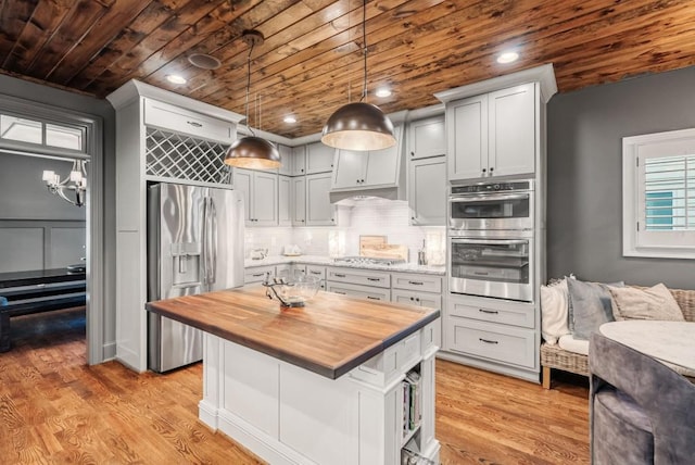 kitchen with wooden ceiling, appliances with stainless steel finishes, light hardwood / wood-style floors, and butcher block counters