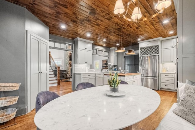 dining room with wood ceiling and light wood-type flooring