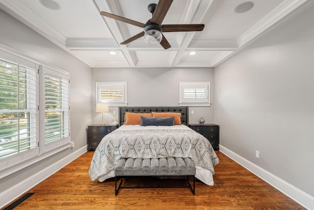 bedroom featuring beam ceiling, ceiling fan, wood-type flooring, crown molding, and coffered ceiling