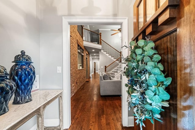 hallway featuring dark hardwood / wood-style floors and brick wall