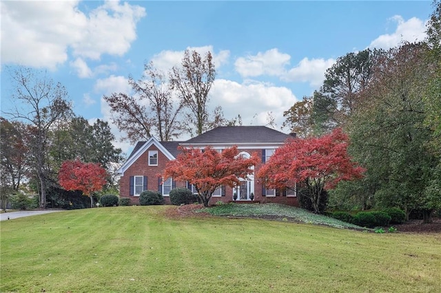 colonial-style house featuring a front yard