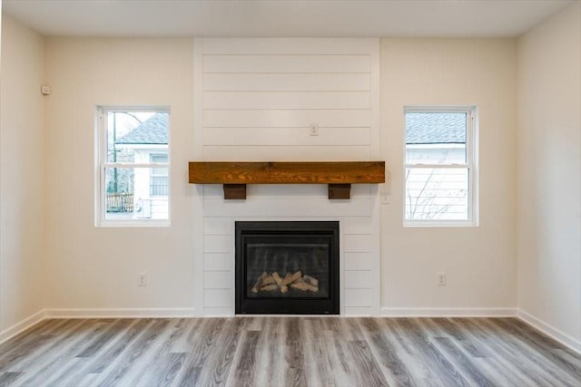 unfurnished living room featuring a fireplace and light hardwood / wood-style floors