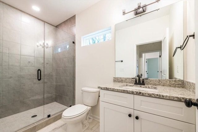 bathroom featuring a shower with door, vanity, and toilet