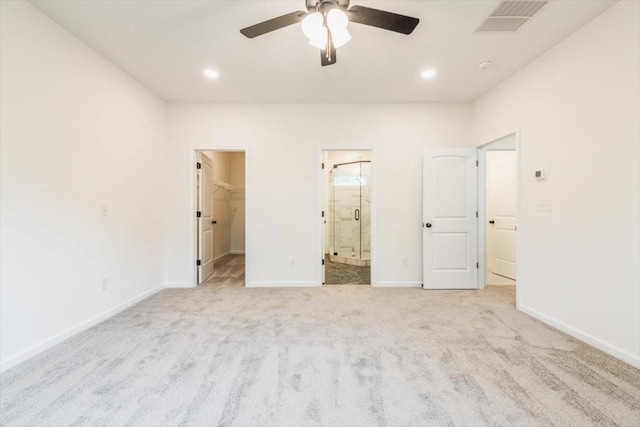 unfurnished bedroom featuring ensuite bath, ceiling fan, light carpet, a spacious closet, and a closet