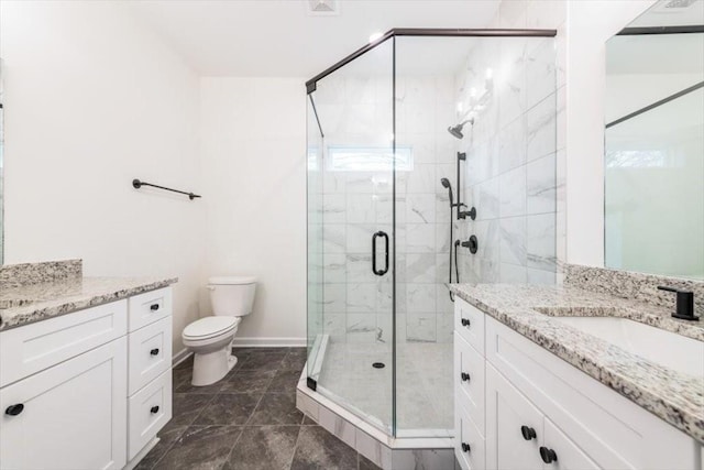 bathroom with vanity, a shower with shower door, and toilet